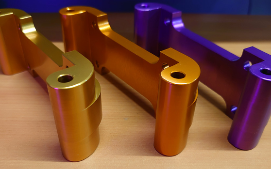 A picture of our Rear Upper Suspension Arms, arrayed in the colours of gold, purple and orange.