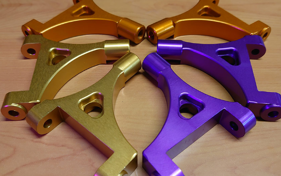 A picture of our Rear Upper Suspension Arms, arrayed in the colours of gold, purple and orange.
