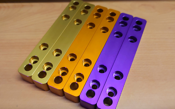 A picture of our Roll Bar Connectors, arrayed in the colours of gold, purple and orange.
